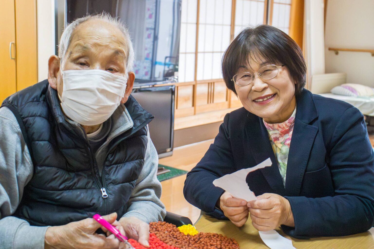 介護施設での入居者とスタッフによるレクリエーション活動。手作業の工芸品制作に取り組む様子。